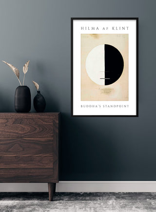 Framed "Buddha's Standpoint" poster by Hilma af Klint hanging on a dark wall above a wooden dresser.