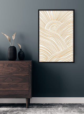 Magical Lines Plakat with abstract golden lines in a black frame, hanging on a dark wall above a wooden dresser.