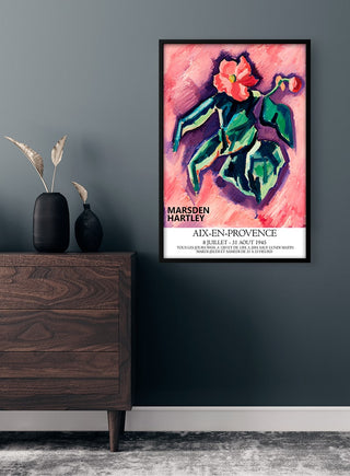 Framed Pink Begonias - Marsden Hartley poster on a dark wall above a wooden dresser with vases.