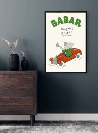 Babar Plakat No. 03 featuring Babar the elephant driving a red car, framed and hanging on a modern wall.