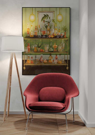 A red lounge chair and floor lamp in front of a "Dinner n Drinks" art print by Martina Karlsson.