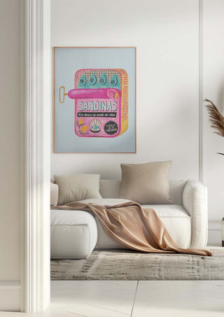 Framed Baroo Bloom Sardines Tin Can artwork hanging above a white sofa in a modern living room.