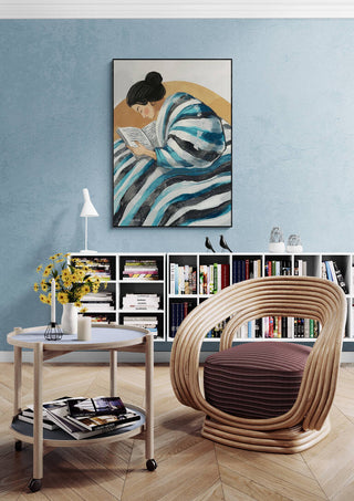 Framed "Eyes Are Made For Reading" by Martin Zen displayed above a modern reading nook and bookshelf.