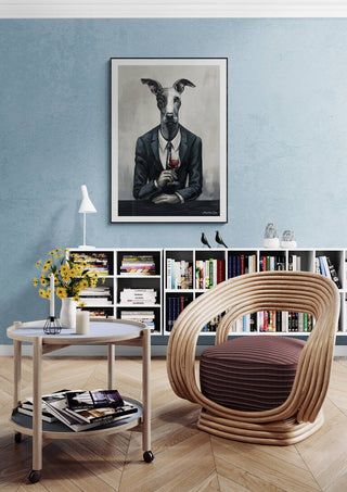Art print of a dog in a suit titled "Boss Man - Martin Zen" hanging in a modern reading nook with chair and shelves.