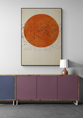Framed "Birds In the Sun" by Boris Draschoff above a modern sideboard with lamp in a minimalist room.