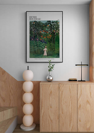 Framed print of Henri Rousseau's "Femme Se Promenant" hanging above a modern wooden sideboard.