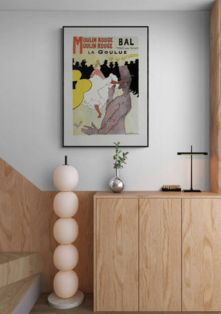 Framed Pour Le Moulin Rouge - Lautrec vintage poster displayed above a wooden cabinet in a modern room.