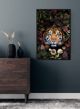 Poster of a tiger surrounded by colorful flowers, displayed on a dark wall above a wooden dresser.
