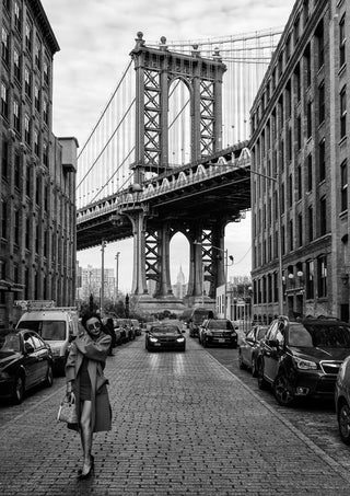 Black and white photo of a woman walking under Manhattan Bridge, featured on Oblivious by Robert Bolton product page.