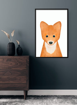 Framed children’s poster of a cute orange fox with big eyes, displayed on a dark wall above a wooden dresser.