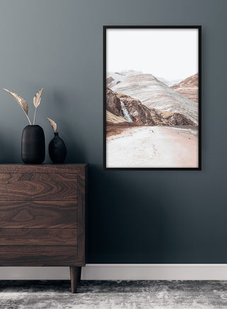 Framed Mountain and Clouds Plakat hanging above a wooden dresser in a modern room.