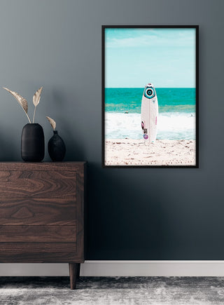 Framed Surfboard on Beach Plakat hanging on a dark wall above a wooden dresser in a modern interior.