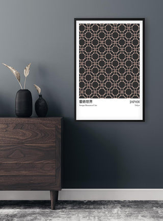 Black Dots Japan Exhibition Plakat framed on a gray wall above a dark wood dresser with minimalist decor.