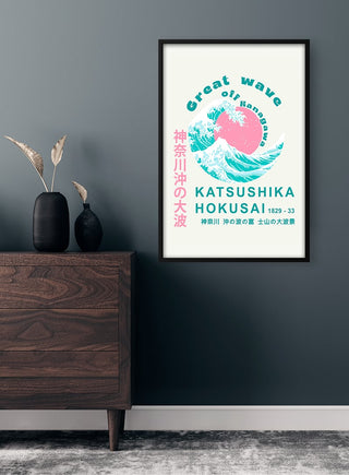 Framed "The Great Wave" pink poster by Hokusai hanging on a wall above a modern wooden dresser.