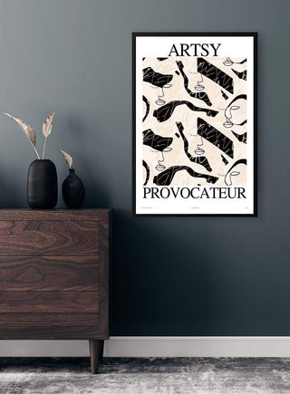 Artsy Provocateur No. 03 Plakat framed on a dark wall above a wooden dresser with vases and dried plants.