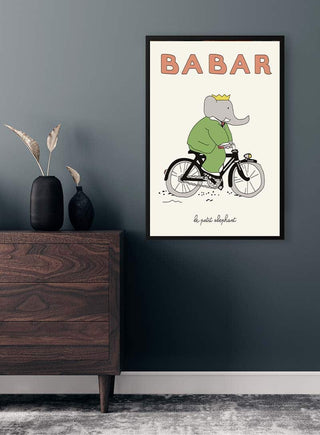 Framed Babar Plakat No. 02 featuring Babar the elephant riding a bicycle, displayed on a modern wall.