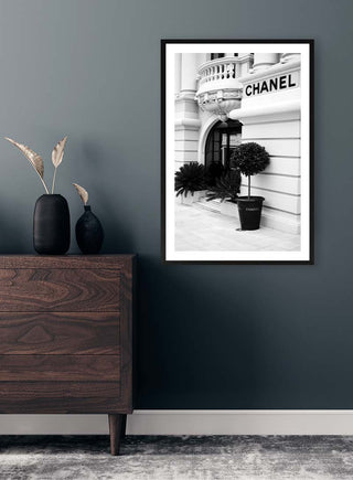 Black and white photo of a Chanel boutique entrance, framed and displayed on a modern interior wall.
