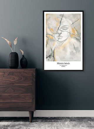 Framed "Broken Mirrors" by Kate Aitana art print displayed on a dark wall above a wooden dresser.