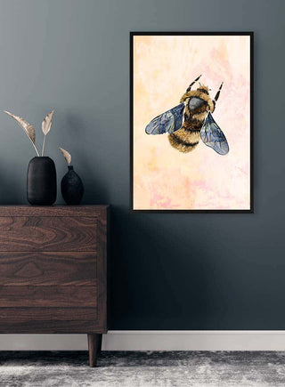 Framed Rustic Bee art print hanging above a wooden dresser in a modern, minimalist room.