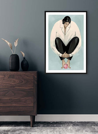 Framed print of "I Think I Am Alone Now" by Martina Karlsson displayed on a dark wall above a wooden dresser.