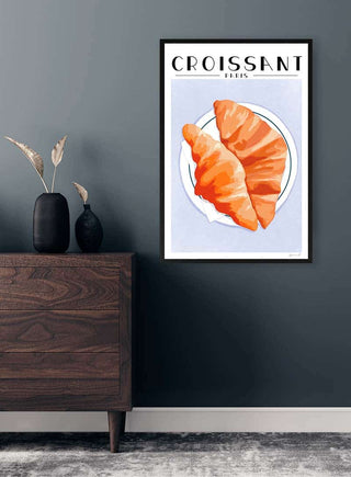 Framed croissant wall art on a dark blue wall above a wooden cabinet, styled for Altan Hygge - ByKammille.