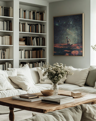 Framed "Nostalgia" by Frank Moth displayed above a neutral sofa in a cozy, book-filled living room.
