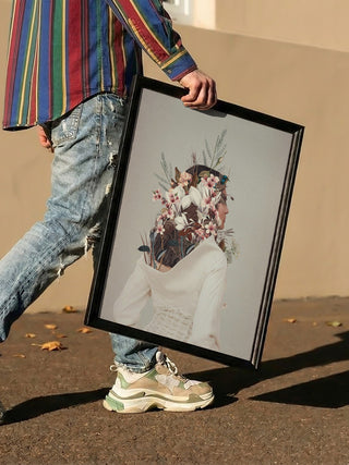 Person holding a framed "You Gifted Me an Autumn" print by Frank Moth, featuring floral surrealist art.
