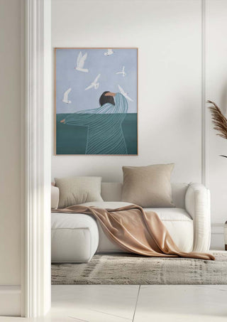 Framed "Seaside" by Bea Muller above a white sofa in a modern living room with neutral decor.