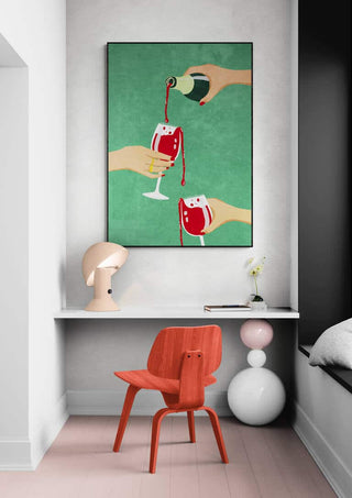Art print "Cheers Girls" by Raissa Oltmanns featuring hands pouring wine, displayed above a modern desk setup.