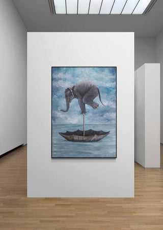 Art print of an elephant balancing on an umbrella above water, displayed in a modern gallery setting.