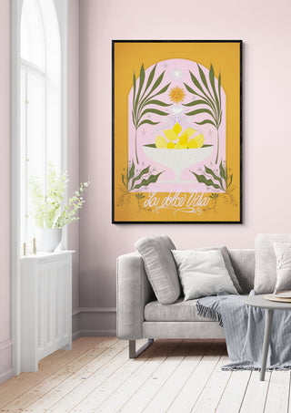 Framed La Dolce Vita Lemons - Baroo Bloom print on a pink wall above a light grey sofa in a bright living room.