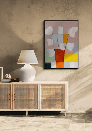 Abstract Flowerpot by David Wolf framed on a beige wall above a sideboard with lamp and decor.