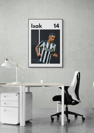 Alexander Isak Football Poster featuring player in black and white striped jersey, displayed above a modern desk.