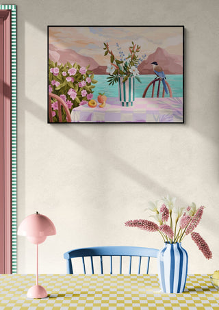 Framed Peachy Evenings - Goed Blauw artwork above a pastel dining table with flowers and a pink lamp.