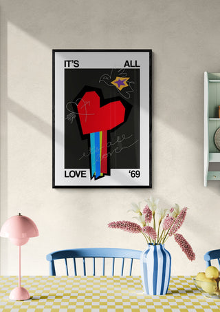 Framed All Love Black art print with a bold heart design, hanging above a dining table in a bright room.