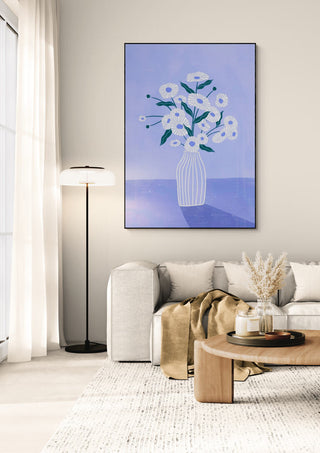 Flowers In Blue by Bea Muller displayed above a modern sofa in a bright, stylish living room.
