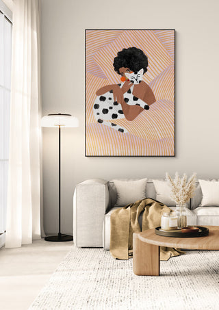 Framed artwork of a woman cuddling a spotted cat, displayed above a modern sofa in a cozy living room.