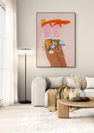 Art print of floral socks by Bea Muller displayed above a modern sofa in a cozy, neutral-toned living room.