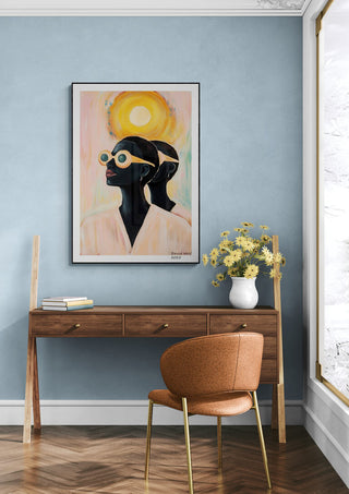 Framed "Sun Away" by David Wolf on a blue wall above a wooden desk with flowers and an orange chair.
