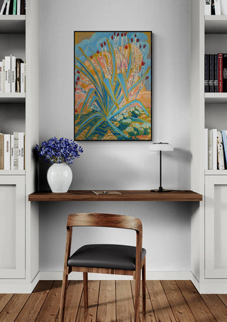 Agave Plant by Eleanor Baker framed on a wall above a desk with a vase of purple flowers and bookshelves.