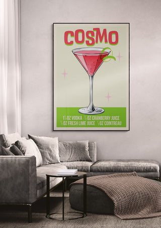 Cosmo wallchart featuring a cosmopolitan cocktail recipe, hanging above a modern gray sofa in a living room.