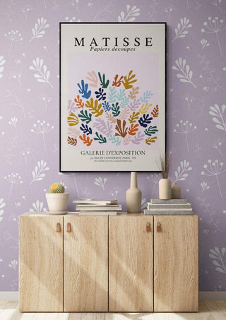 Matisse The Sheef Refurbished art print above a light wood cabinet, set against a lavender floral wallpaper.