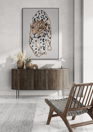 Framed "Il Leopardo No.I" by Gabriella Roberg displayed above a wooden console in a modern living room.