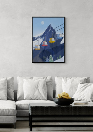 Framed ski lift art print above a modern gray sofa, featuring cable cars on snowy mountain slopes.