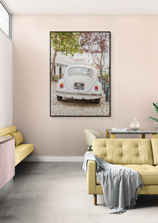 Framed photo of a classic car in Cascais hanging above modern sofas in a stylish living room.