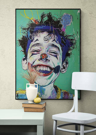 Colorful painting of a smiling clown-faced child on a green background, displayed above books and a vase.