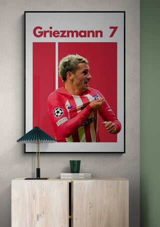 Football poster of Antoine Griezmann in red kit, with "Griezmann 7" text, displayed on a wall above a cabinet.