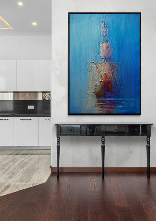 Ship by Justyna Kopania displayed above a black console table in a modern room with wood flooring.